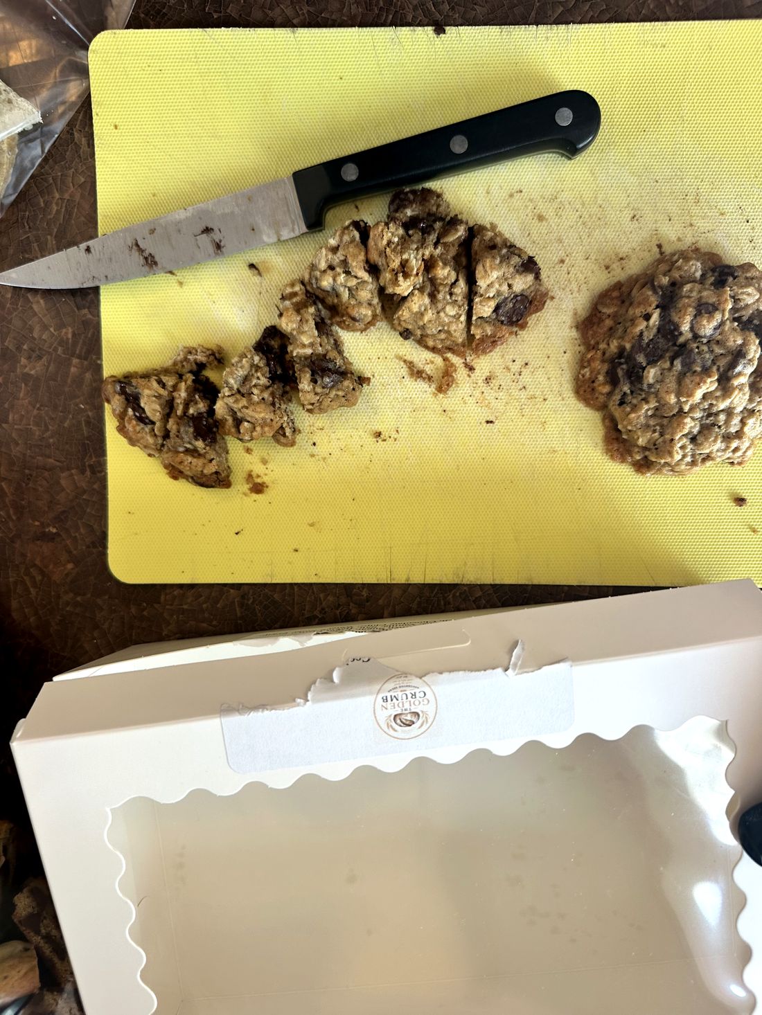 Sourdough oatmeal chocolate chip cookie being portioned for the box