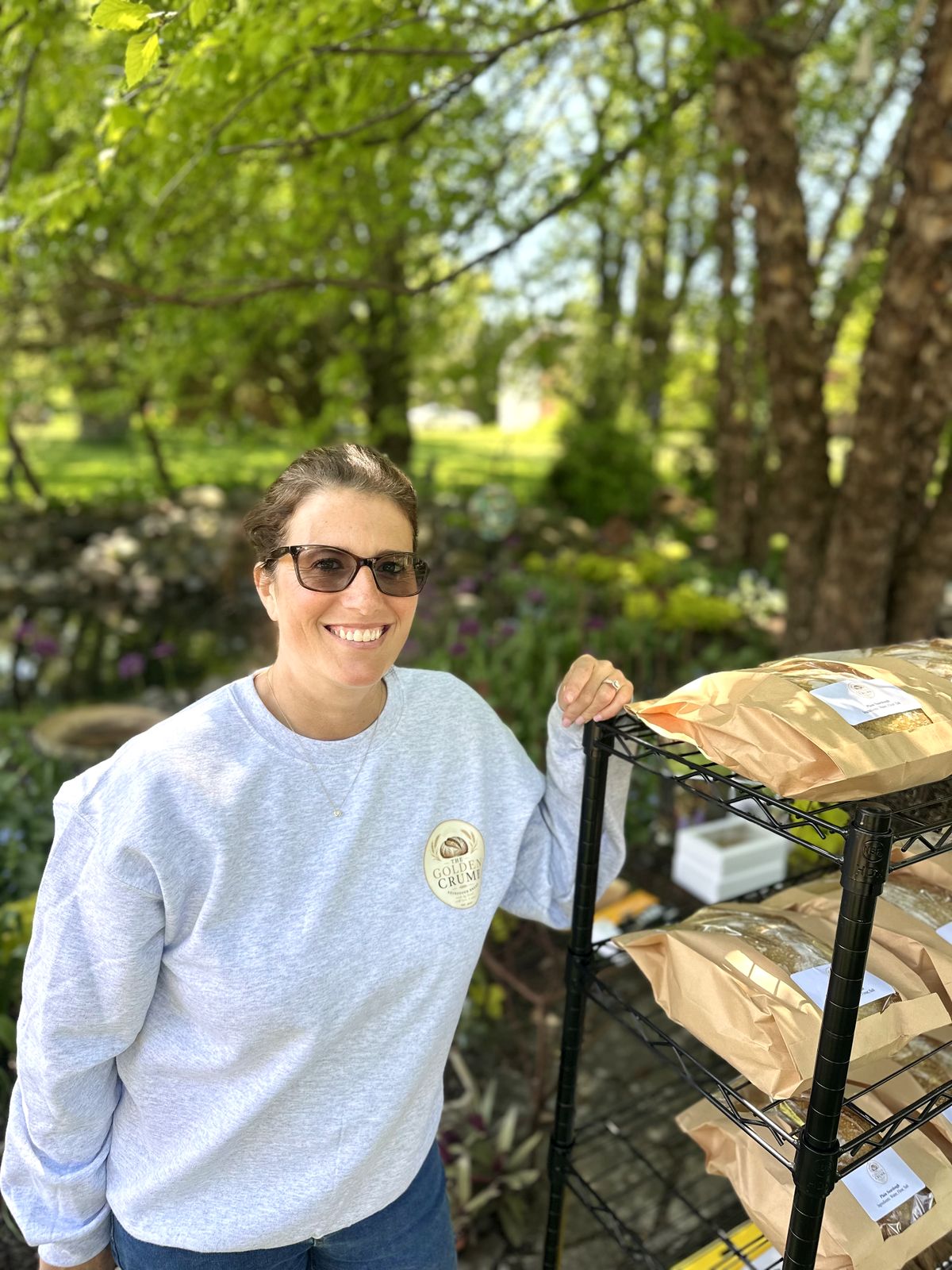 Michelle, smiling at her booth in her Golden Crumb sweatshirt