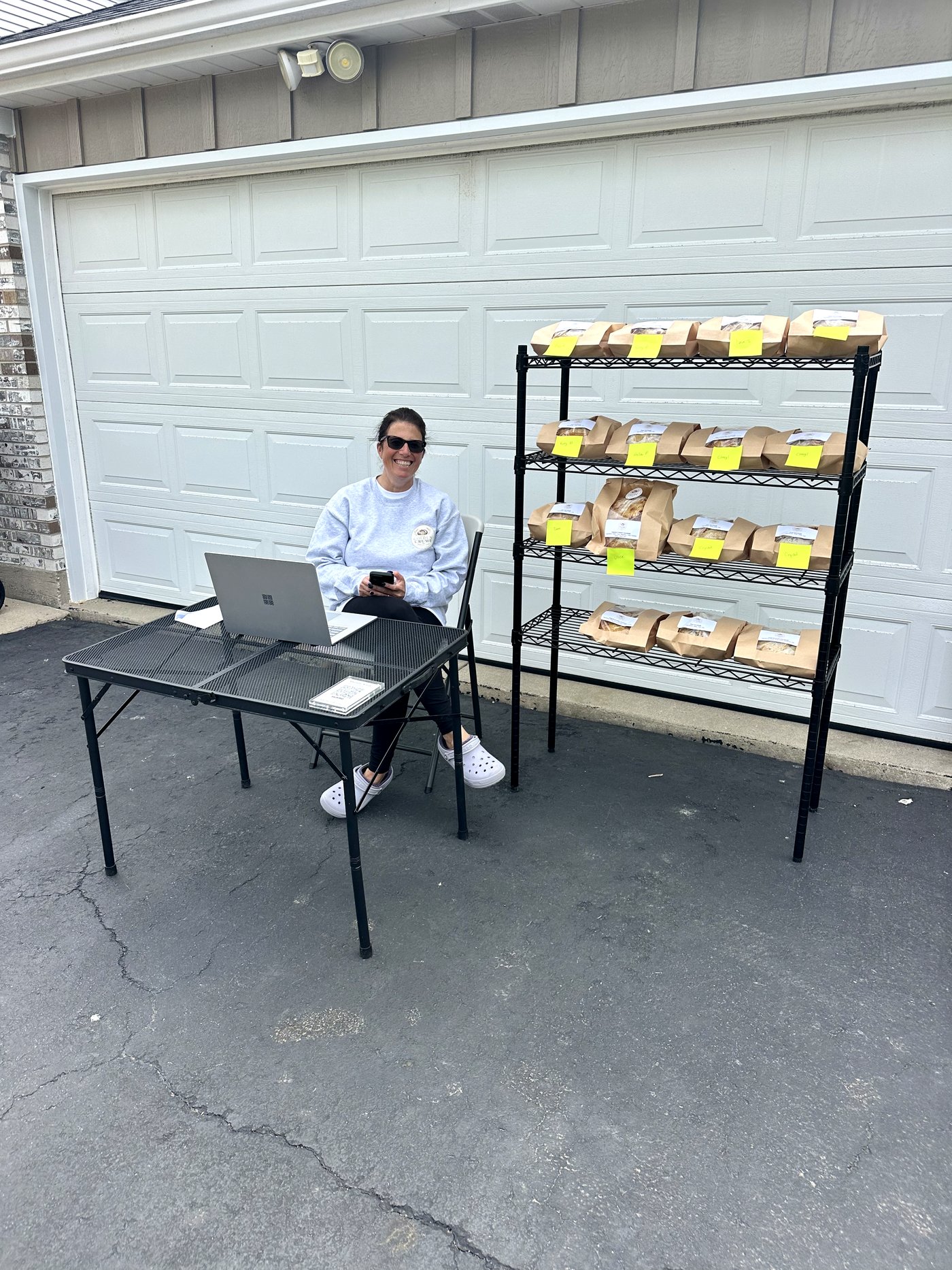 Michelle smiling at her pickup-day setup with the bread shelf beside her